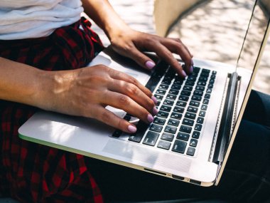 Kadın eli dizüstü bilgisayarın klavyesine yazar. Uzaklık öğrenimi çevrimiçi eğitim