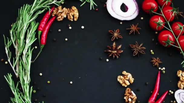 Rosemary padá na černé pozadí s červenými rajčaty, červenými chilli papričkami a kořením — Stock video