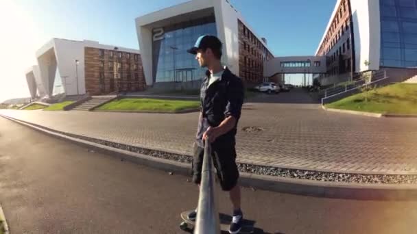 Чоловік їде на скейтборді в місті на заході сонця . — стокове відео