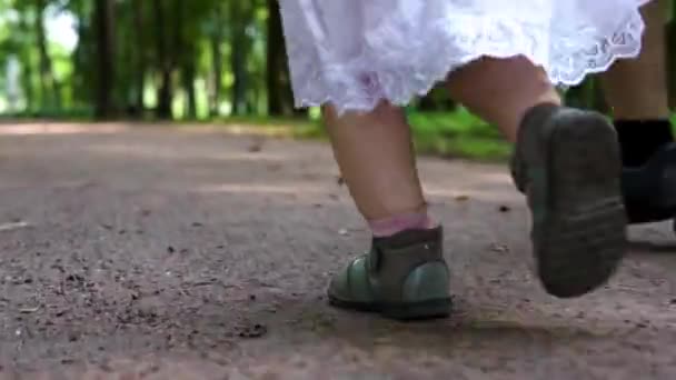 Barnens fötter i sandaler som löper genom parken. Närbild — Stockvideo