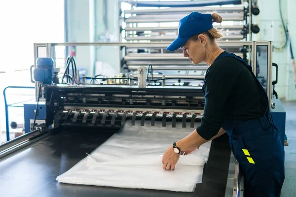 Γυναίκα εργαζόμενος στην παραγωγή πλαστικών συσκευασιών πτυχώσεις τελικών προϊόντων — Φωτογραφία Αρχείου