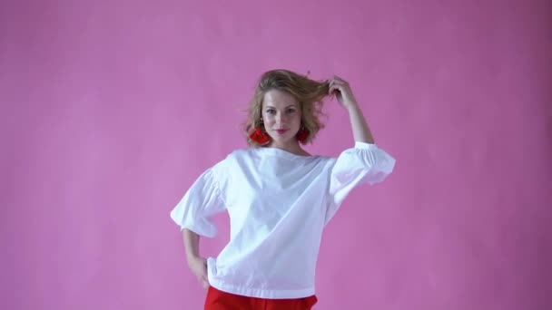 쾌활 한 긍정적인 금발 소녀 핑크 배경에 사진 스튜디오에서에서 카메라 포즈 — 비디오