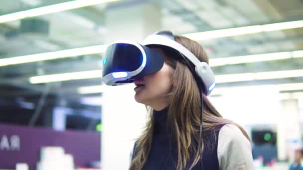 Menina com óculos de realidade virtual. Conceito de tecnologia futura. Testando o aplicativo em realidade virtual — Vídeo de Stock