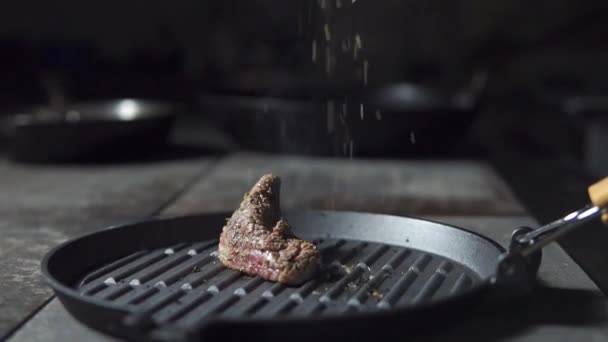 Vlees dat is gebakken in een pan besprenkeld met kruiden — Stockvideo