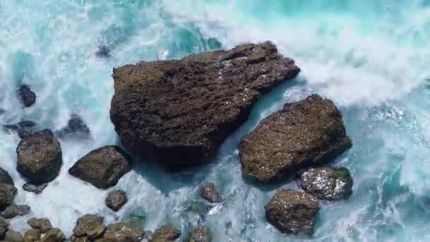Вид сверху на океанский берег с волнами, ударяющимися о скалы — стоковое видео
