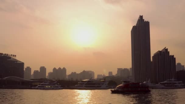 Xangai, China - 15 de janeiro de 2018: silhuetas de edifícios e navios que navegam no rio Huangpu ao pôr-do-sol — Vídeo de Stock