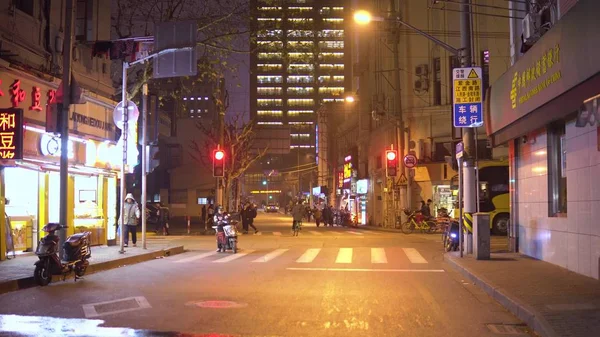 Shanghai, China - 15 de enero de 2018: Colorida calle de neón en la que los scooters de motor están conduciendo cerca de Nanjing Road por la noche —  Fotos de Stock