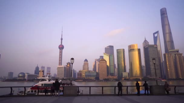 Shanghai, Chine - 15 janvier 2018 : Des gens marchent le long du remblai du Vaitan dans le contexte de la rivière Huangpu et des gratte-ciels au coucher du soleil — Video