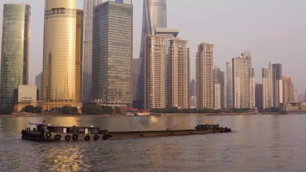 Lastat pråm med krossad sten nedför floden Huangpu mot bakgrund av glas skyskrapor i centrum av Shanghai — Stockvideo