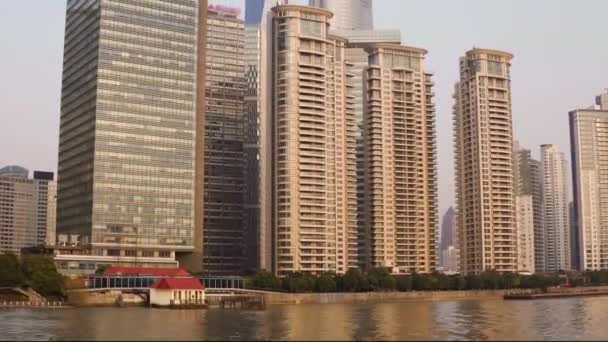 Hermoso paisaje urbano con rascacielos de cristal a lo largo del río Huangpu sobre el telón de fondo del sol poniente — Vídeos de Stock