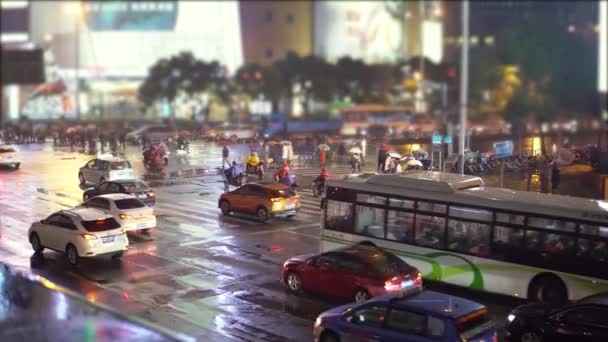 Autos und Busse fahren mit Leuchtwerbung und Taschenlampen die Straße hinunter, Menschen mit Regenschirmen laufen die Straße entlang. — Stockvideo