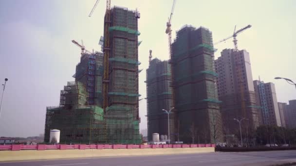 Bouwplaats van een typische ontwikkeling met bossen en kranen in de residentiële wijk van Shanghai, China — Stockvideo