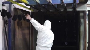 koruyucu elbiseli bir adam fırının kapılarını açar ve orada ayrıntıları getiriyor