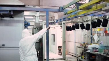 koruyucu elbiseli bir adam fırının kapılarını açar ve orada ayrıntıları getiriyor