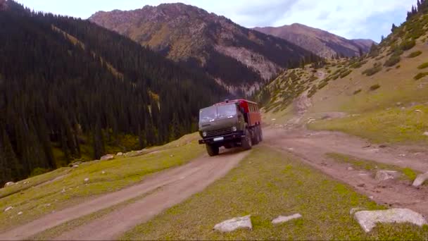 Caminhão de passageiros off-road no fundo das montanhas — Vídeo de Stock
