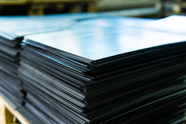 Steel sheets deposited in stacks in packs at the warehouse of metal products. Weathered metals sheet for construction. Metal corrosion