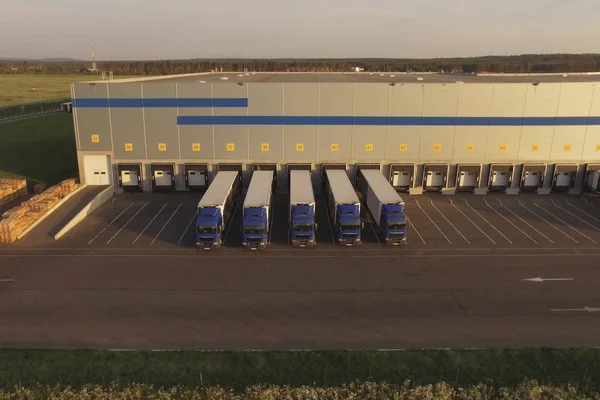 Grande complexo de armazéns com caminhões estacionados aguardando carga. Centro de logística, terminal de armazém Imagens Royalty-Free