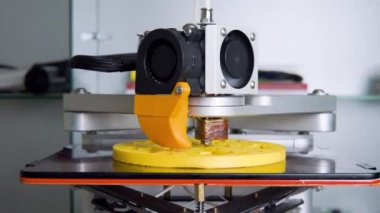 3D yazıcı, sarı nesneleri yakın çekimde basıyor. Modern teknik 3D yazdırma