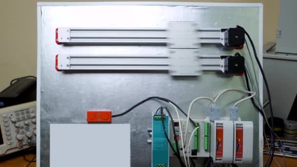 Demonstratiestand met de mogelijkheden van moderne elektronica. Reeks servomotoren verbonden met een microcontroller voor automatische besturing van een robotplatform — Stockvideo