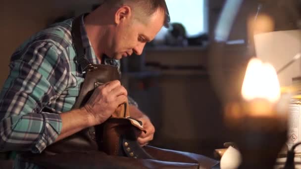 빈티지 효과가 있는 신발을 만들기 위해 가죽을 가공하는 과정에서 숙련 된 제화 업자와 함께 일 했던 고대 작업장 — 비디오