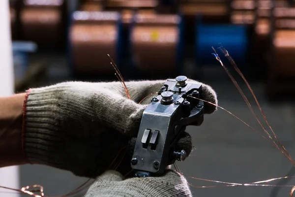 Las manos con guantes conectan el cable de cobre al núcleo con una herramienta especial — Foto de Stock