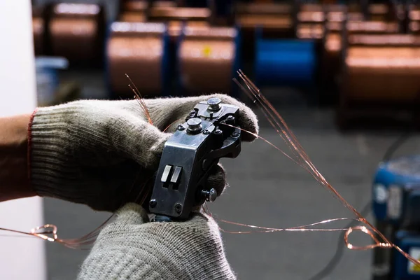 gloved hands connect the copper cable to the core with a special tool