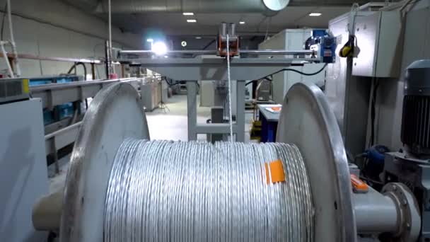 Egy elszigetelt elektromos kábelt tekercselnek egy fémtekercsen — Stock videók