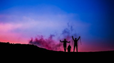 Bir grup Yürüyüşçü Alacakaranlık Gökyüzüne Karşı Siluet Yaptı. Sahne, bir başarının, maceranın ve bir yolculuğun ortak güzelliğinin hissini uyandırıyor..