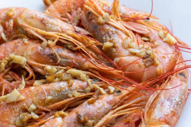 Beyaz tabakta limonlu ve sarımsaklı kızarmış gambonlar.