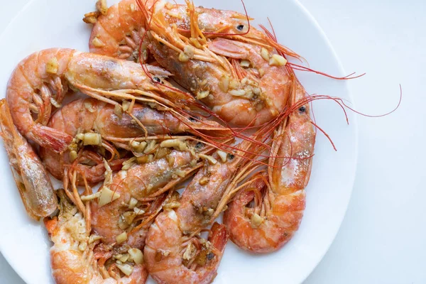 Beyaz tabakta limonlu ve sarımsaklı kızarmış gambonlar.