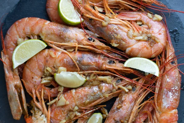 Siyah tabakta limonlu ve sarımsaklı kızarmış gambonlar.