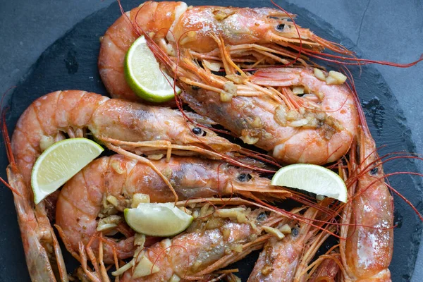 Siyah tabakta limonlu ve sarımsaklı kızarmış gambonlar.