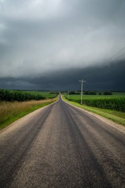 Her iki taraf tehlikeli bir fırtına gibi cornfields ile kırsal bir midwest ülke sokaktan aşağı seyir yaklaşımlar.  