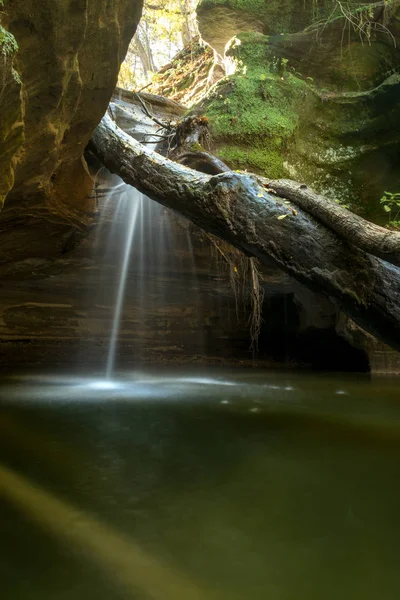 light shining on the water cascading over the waterfall in Kaskaskia canyon, Starved Rock state park, Illinois.