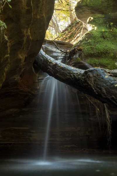 light shining on the water cascading over the waterfall in Kaskaskia canyon, Starved Rock state park, Illinois.