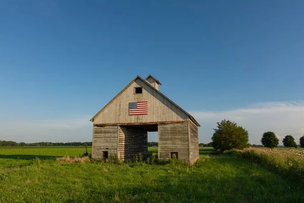 Amerikan bayrağı ile eski ahşap ahır. — Stok fotoğraf