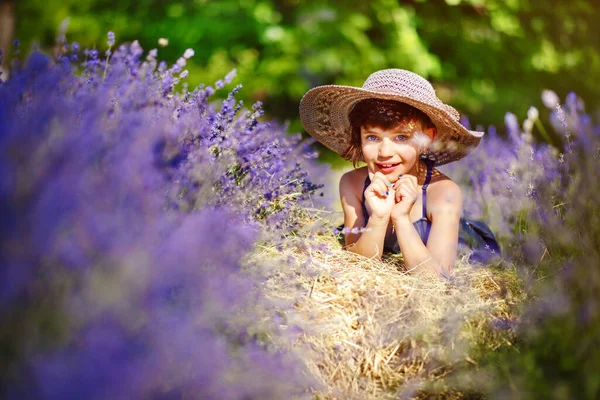 Cute Little Smiling Girl Noszenie Niebieskiej Sukienki Biały Kapelusz Leżące — Zdjęcie stockowe