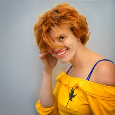 Gülümseyen, cilveli orta yaşlı, beyaz, sarı saçlı, broşlu, güzel moda tarzı olan, kıvırcık saçlı, beyaz bir kadının yakın plan portresi.