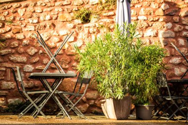 Sabahın erken saatlerinde Provence, Fransa 'da kapalı bir restoranda masalar. Seyahat turizm beldesi. Tüm yıl boyunca en düşük mevsim 2020. Portakal rengi köy Roussillon 'da sabah ışığı.