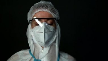 Koronavirüs salgını yüzünden çok sayıda hasta aldıktan sonra yorgun kadın doktor. Şapka ve yüz koruyucu maskeyle Gözlük takarak.
