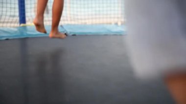 Oğlan ve kız denizde eğlenceli bir yaz tatili geçiriyorlar. Gün batımında plajda trambolinde zıplayan iki çocuğun bacaklarını kapat. Çocukluk ve aktif aile hayatı kavramı.