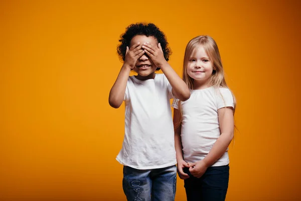 Anak laki-laki berkulit gelap menutup matanya dan menghitung sampai sepuluh sehingga gadis berambut panjang gadis itu memiliki waktu untuk menyembunyikan — Stok Foto