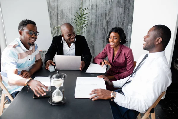 Dark skinned members of the board of directors discuss the company\'s development strategy in office