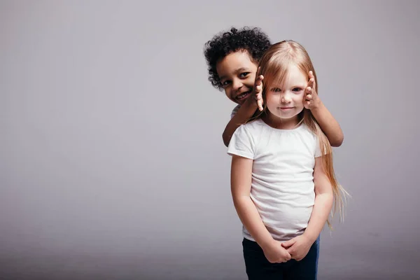 Krullenbol zwarte jongen bedekt oren van zijn vriendin, zodat ze niet zou luisteren over racisme in de wereld — Stockfoto