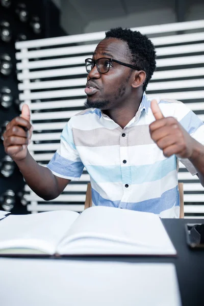 Αιθίοπας φοιτητής με γυαλιά δείχνει δύο αντίχειρες προς τα πάνω ως ένδειξη ότι είναι έτοιμος για εξετάσεις στο πανεπιστήμιο. — Φωτογραφία Αρχείου