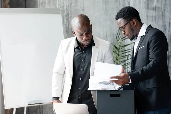 A black employee shows the director in a white jacket statistics of the damage caused by a malfunction in the country during strikes.