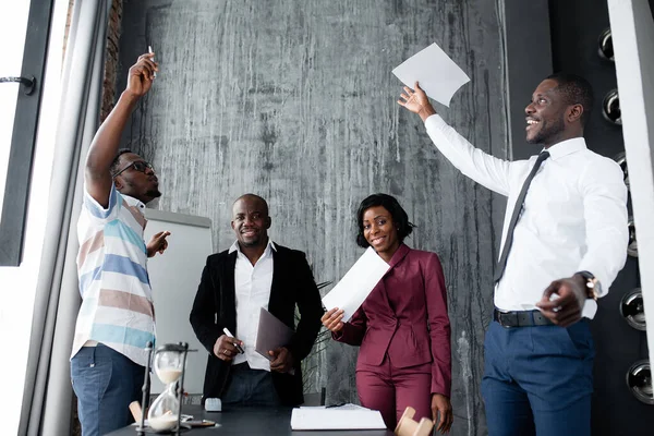 Afro-americanos na empresa dispersar alegremente documentos para a celebração de um grande contrato no escritório . — Fotografia de Stock