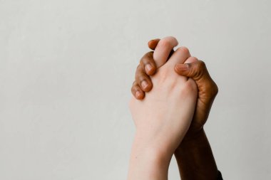 Irkçılığa karşı savaş. Ten rengine ve milliyetine göre iki farklı insan eli sıkıca birbirini sıkıyor.