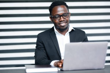 Amerikalı ofis çalışanı bir dizüstü bilgisayarda yeni bir uygulama geliştiriyor. Profesyonel bir programcının iş akışı.