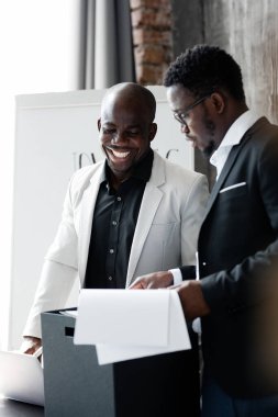 İş ortakları sözleşmenin detaylarını toplantıdan önce tartışırlar. İşadamları belgeleri değerlendiriyor..